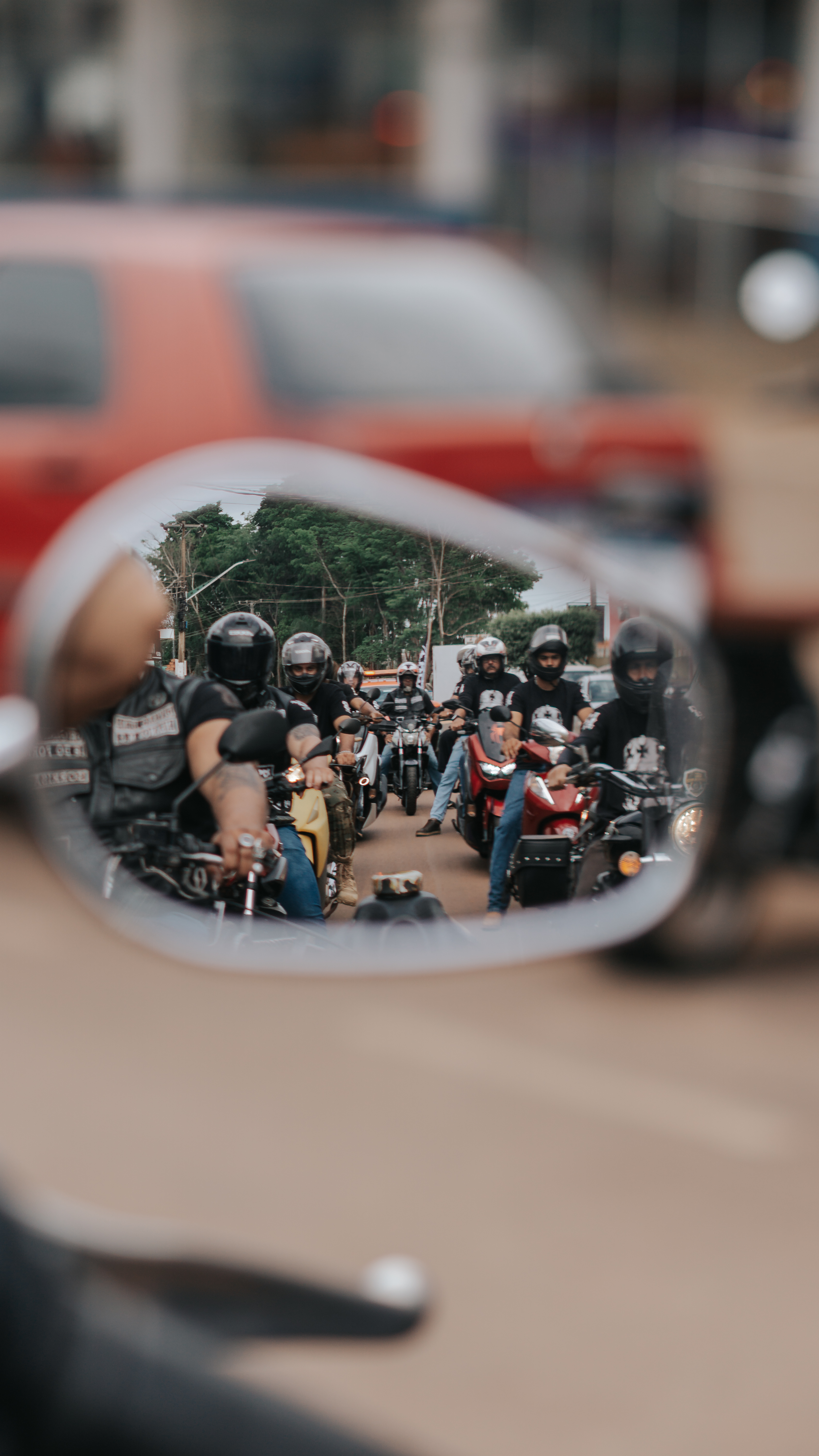 Grupo de motociclistas refletido no retrovisor de uma moto